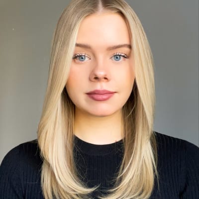 Porträttbild av kvinna med långt blont hår och blåa ögon.