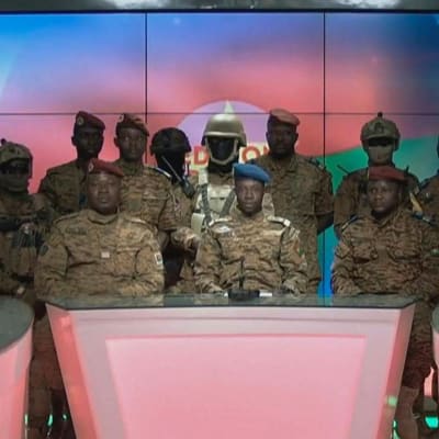 Skärmdump från militärens tv- och radiosända tal den 24 januari 2022. En talesperson för militärjuntan, Sidsore Kader Ouedraogo, sitter i mitten omgiven av ett flertal soldater.