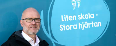 Utbildningschef Timo Tenhunen vid en skylt i Isnäs skola i Lovisa