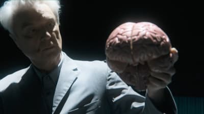 David Byrne pitelee kädessään aivoja. Kuva konserttielokuvasta David Byrne's American Utopia.