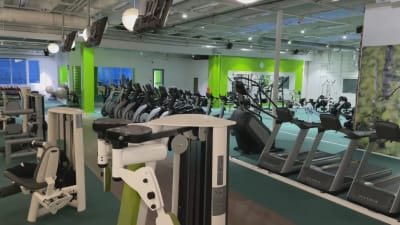 Bild av ett tomt gym med olika motionsapparater. 