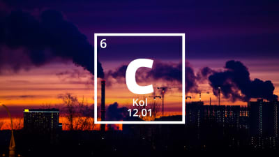 Kolets kemiska förkortning C.  I bakgrunden en stadsvy med höghus och skorstenar i solnedgång.