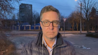 Yles reporter Antti Kuronen står framför höghus.