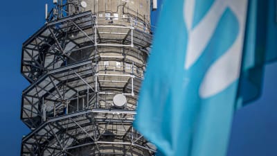 Yles sändningstorn i Böle i bakgrunden. I förgrunden en del av en Yleflagga.