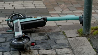Kaatunut sähköpotkulauta kadulla.