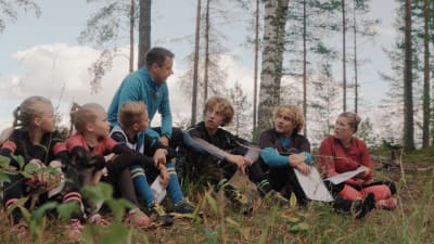 Kuva on sarjasta Pysy kartalla. Kuvassa sarjan esiintyjät istuvat metsässä.