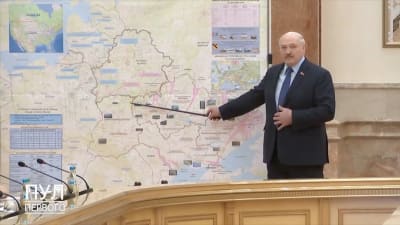 Belarus diktator Aleksandr Lukasjenko pekar på en rysk karta soim beskriver det ryska angreppet mot Ukraina.