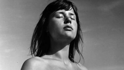 Nuori nainen (näyttelijä Harriet Andersson) silmät kiinni auringossa. Kuva elokuvasta Kesä Monikan kanssa.