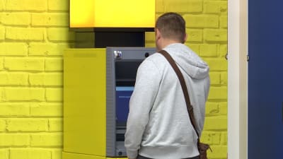 Mies nostaa rahaa käteisautomaatista Vaalimaalla