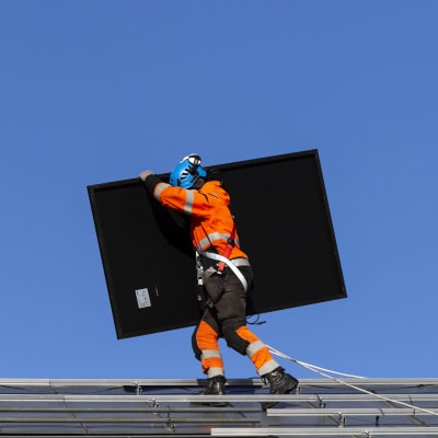 Man installerar solpanel på tak