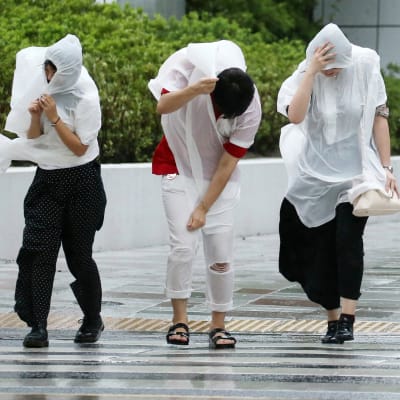 Folk stretar fram i Osaka i den hårda vinden. 