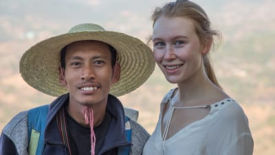 Turistande kvinna fotas med lokal burmes.
