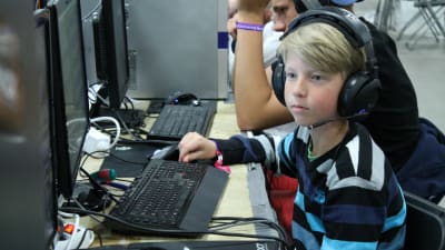 Ung pojke sitter vid en dator.