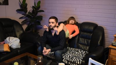 Seval Bitic sitter med sin dotter Latifa på axlarna