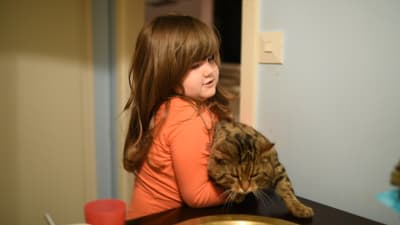 Sevals dotter Latifa lyfter en katt