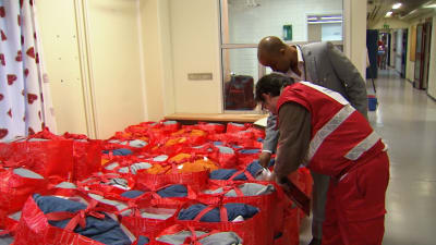Röda Korsets anställda och frivilliga granskar välkomstväska