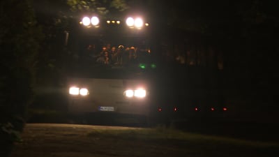 en buss med asylsökande anländer till Patis utanför Åbo, nattbild