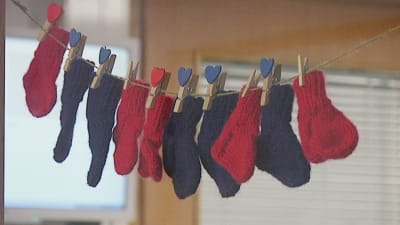 Blå och röda sockor för nyfödda vid Lojo sjukhus förlossningsavdelning.