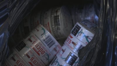 Några torn snus syns inne i en svart sopsäck