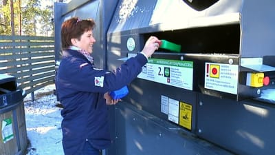 kvinna sätter in plastburkar i återvinningskärl