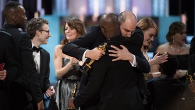 La La Land -elokuvan tuottaja Jordan Horowitz halaa Moonlight-elokuvan ohjaajaa Barry Jenkinsiä.