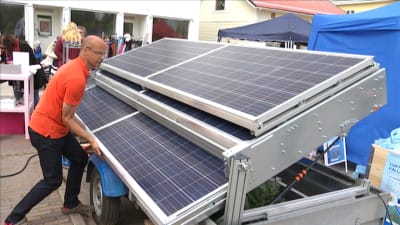 André Lindholm öppnar solpanelerna på Pargas mobila solvagn.
