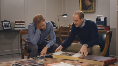 Prinssi Harry ja prinssi William tutkivat valokuva-albumia.