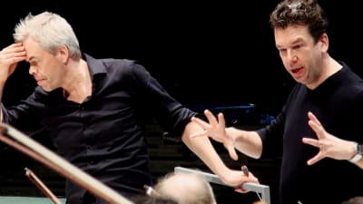Dirigent Hannu Lintu och Sebastian Fagerlund under övning med orkester.