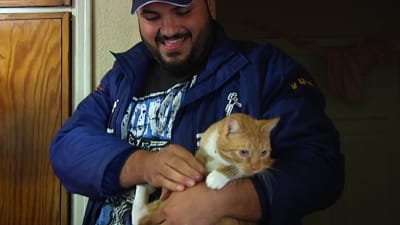 Musa Al-Shirefi med katten Zaza i famnen. 