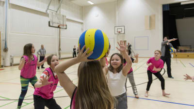 flickor kastar boll i gymastiksal