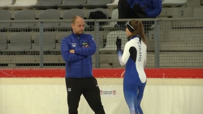 Janne Hänninen och Elina Risku diskuterar på isen i Inzell.