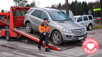 Vardagshjälten Nalle HIndsberg tar ner en bil från flaket. 