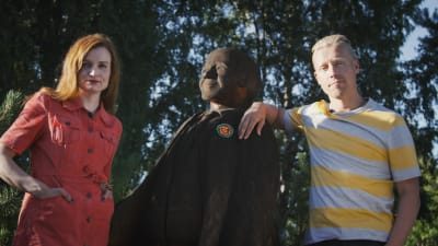 Programledarna Hannamari Hoikkala och Nicke Aldén med en staty av figuren Kalle Kustaa Korkki.