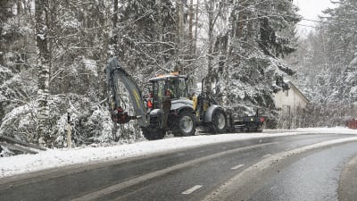 Traktori puhdistaa jalankulkuväylää lumesta
