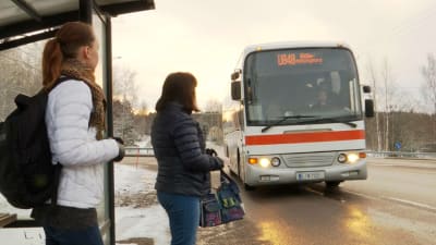 Belinda Andersson står på busshållplatsen och väntar på bussen. Bussen kommer.