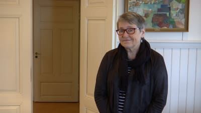 kvinna invid öppen dörr