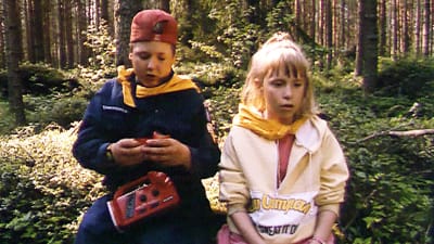 En flicka och en pojke i skogen.
