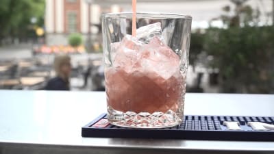 En alkoholfri, rosa drink hälls i ett glas. 