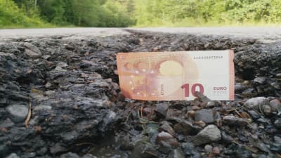 En tio euros sedel i en vägspricka på Ebbovägen i Borgå