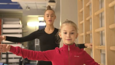 Rytmiska gymnasterna Rebecca Gergalo och Lia Kallio gör balettövningar vid ribbstol.