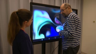 en sjukhuspersonal med klient vid visuell skärm
