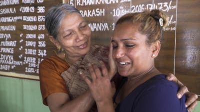 äldre kvinna i indiska kläder tröstar yngre kvinna
