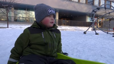 Lucas Sjöholm sitter i en pulka.