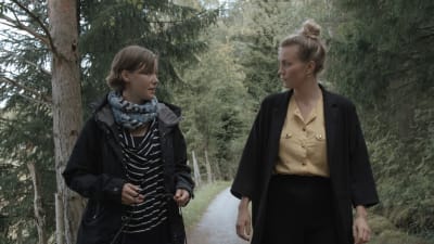 Maria Holmberg och Märta Westerlund promenerar på en skogsväg i Pargas.