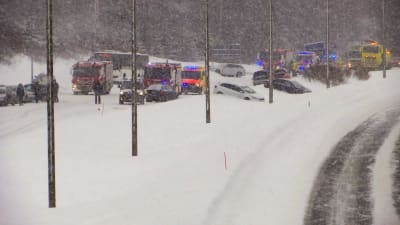 Utryckningsfordon och bilar som kört av vägen in i snödrivor.