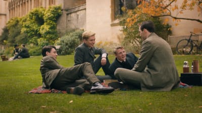 Tolkien och hans tre bästisar sittande på gräsmattan utanför en av universitetsbyggnaderna i Oxford.