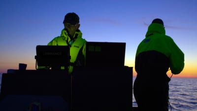 Två män på nattlig båtfärd letar med scanner efter det försvunna skeppet Irma.