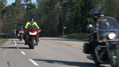 En konvoj motorcyklar längs en landsväg. 