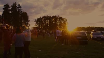 Folkmassor i kvällssolen på parkeringen utanför Klacken