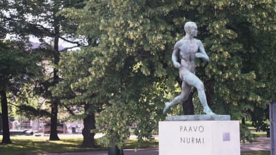 Paavo Nurmis staty framför Olympiastadio i Helsingfors. I bakgrunden syns träd.